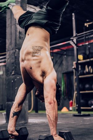 Strong flexible male doing exercise in sport club