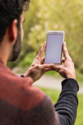 Anonymous man browsing on mobile phone on terrace
