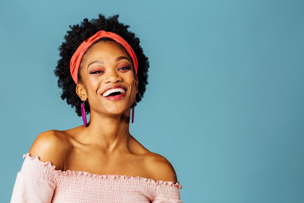 Studio shoot of joyful Black woman smiling at the camera