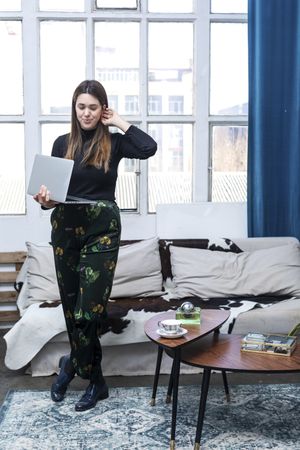 Beautiful business woman standing holding a laptop at home