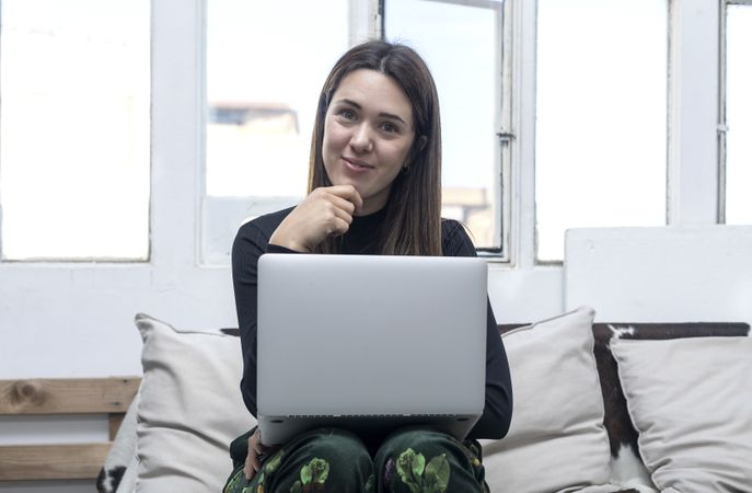 Woman sitting at home and using laptop