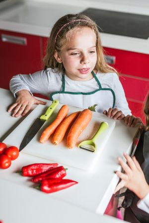 Siblings preparing vegetables for salad