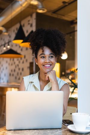 Smiling Black woman browsing laptop