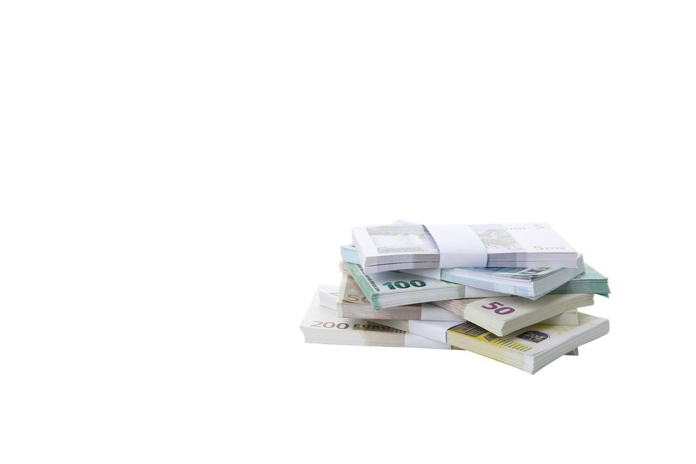 Stacks of Euros in cash, isolated on light background