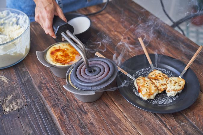Crop person cooking delicious dish at wooden table