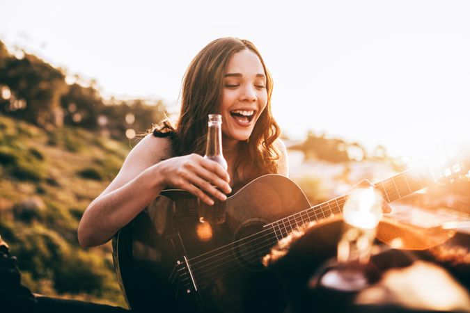 Woman with a guitar and beer
