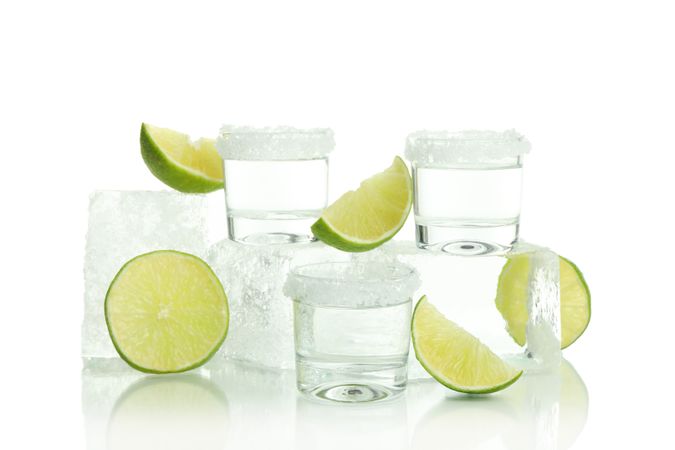 Ice cube pile with of limes and shot glasses