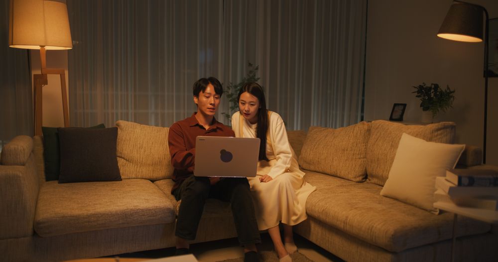 Young and Lovely South Korean Couple Using Laptop Computer in the Evening