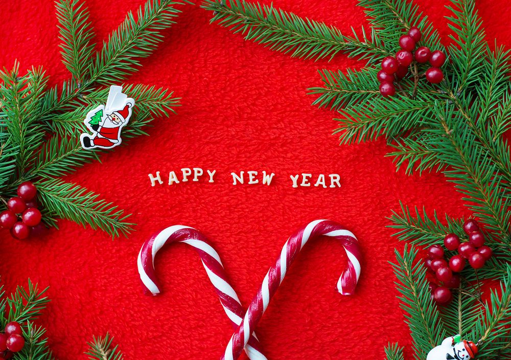 Christmas tree and candy on a red background with the words Happy New Year Postcard