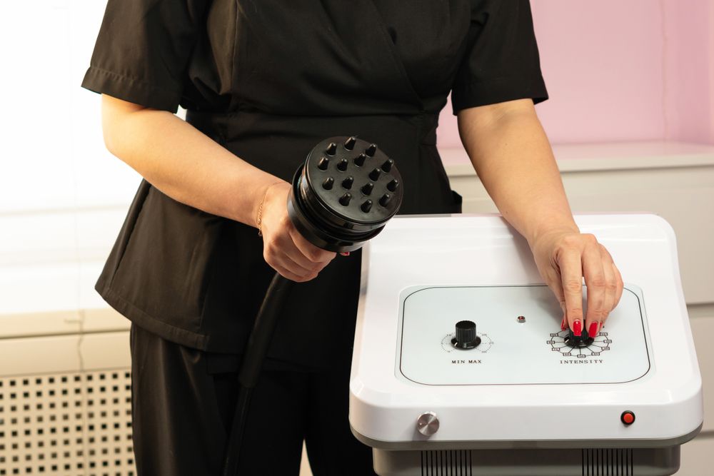 Spa professional adjusts settings on cavitation machine control panel