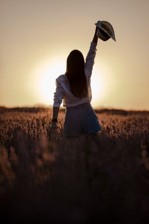 Anonymous woman walking in lavender field