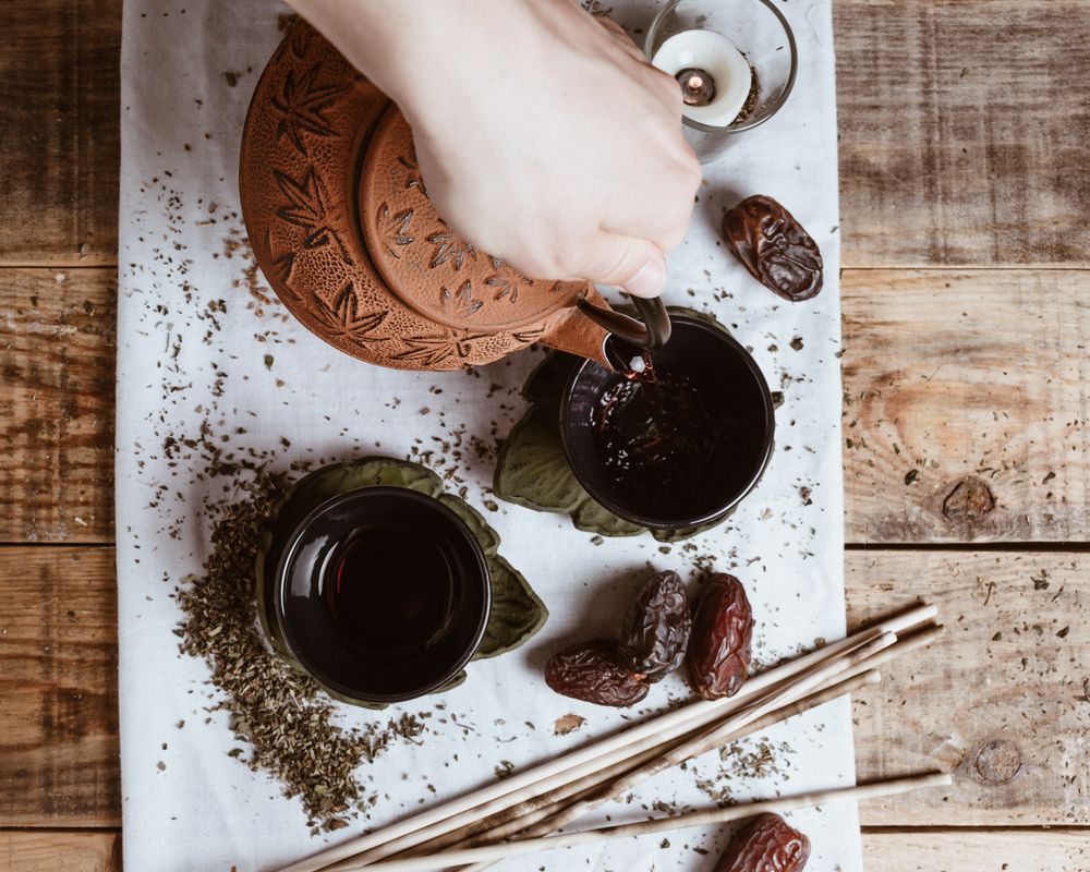 Aromatic tea dates and clay teapot on table