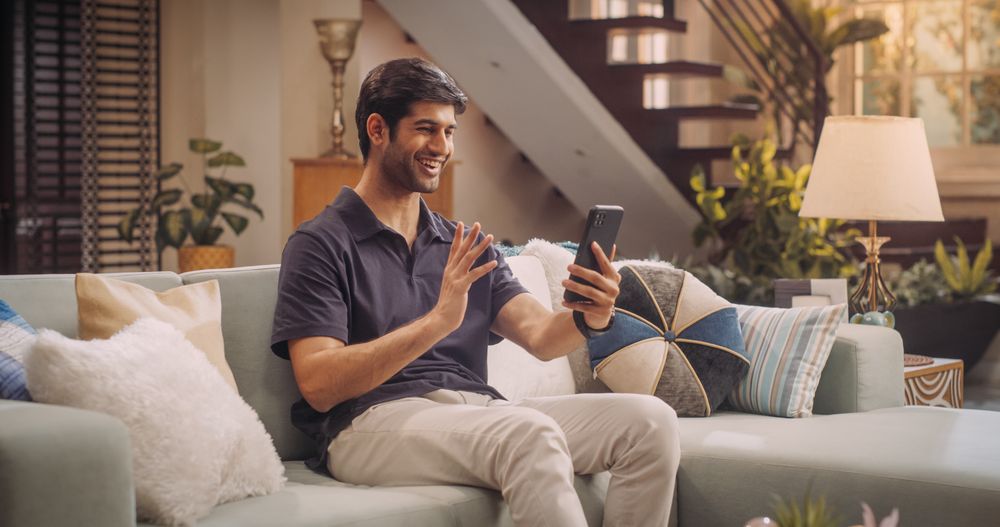 Indian Man Doing in Video Call, Chatting with Friends and Family via Smartphone at Home.