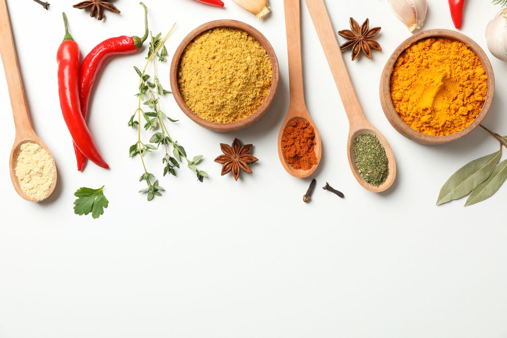 Colorful spices and wooden spoons with copy space