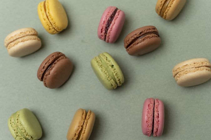Colored tasty macaroons over a green table