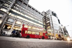 Bus on road near modern building with glass facade