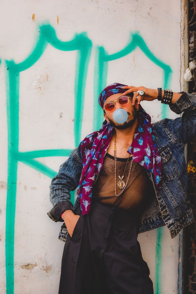 Man blowing bubble gum leaning on wall