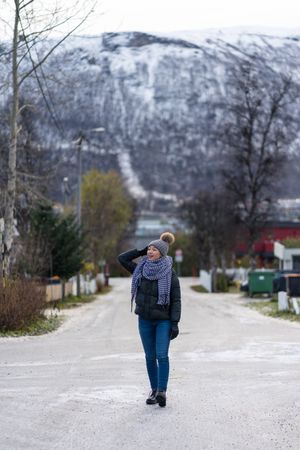Female tourist in warm wear exploring suburbs of city