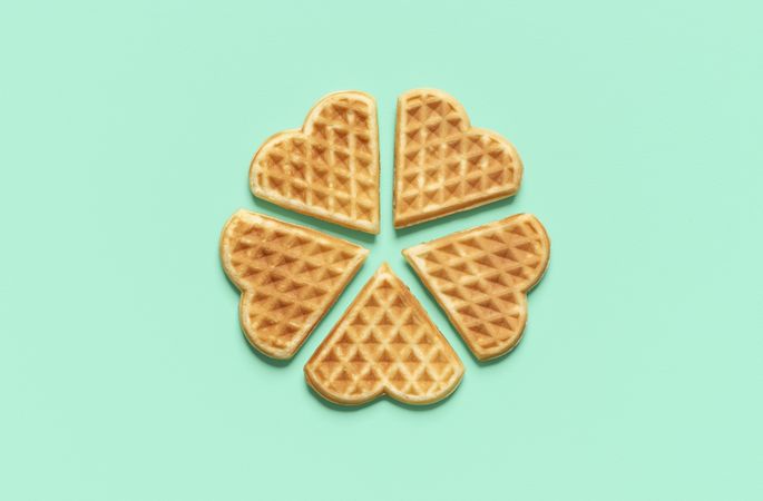 Heart shaped waffles top view on a green table