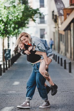 Happy lesbian couple having fun on street