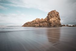 Coastal rock on beach and overcast sky