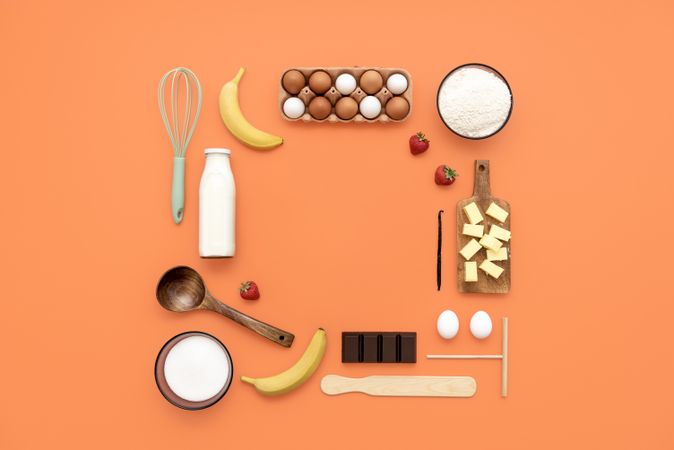 Crepes ingredients and utensils flat lay on an orange table