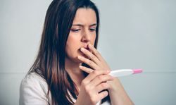Pregnant looking at a pregnancy test