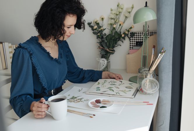 Painter sitting with cup of coffee at work