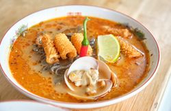 Traditional oriental soup with mussels and crispy chicken skin