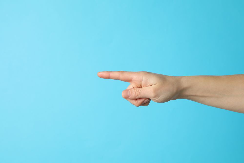Female hand pointing on blue background, space for text