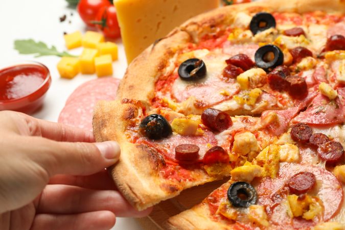 Female hand hold slice of tasty pizza, close up