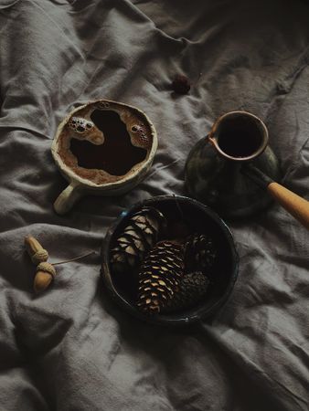 Turkish coffee with bowl of pine cones on bed