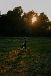Woman kissing dog on meadow