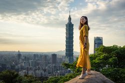 Young resting woman delighting in views in rock at big city