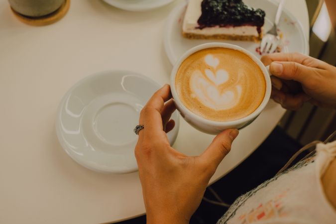 Anonymous woman drinking coffee in cafe