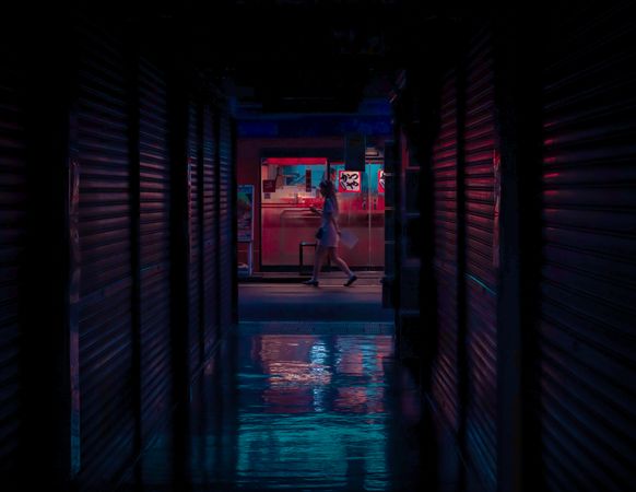 Side view of woman walking in alley at night in Japan