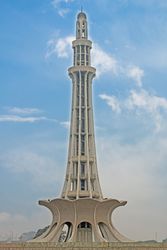 Minaret against blue sky with clouds