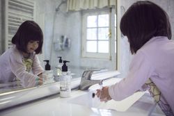Girl washing her hand in in bathroom