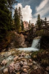 Small waterfall on rocky gorge under bridge