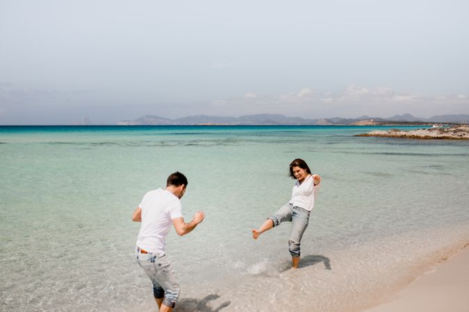 Cheerful lovers having fun on tropical coastline