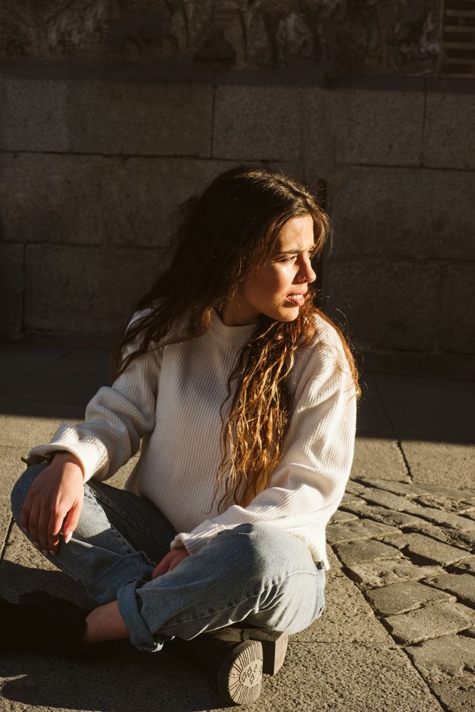 Cheerful woman sitting on pavement
