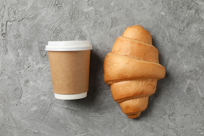 To go coffee and croissant on grey background, space for text