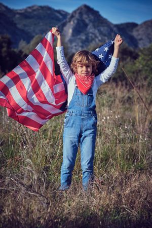 Preteen boy with national American flag in countryside