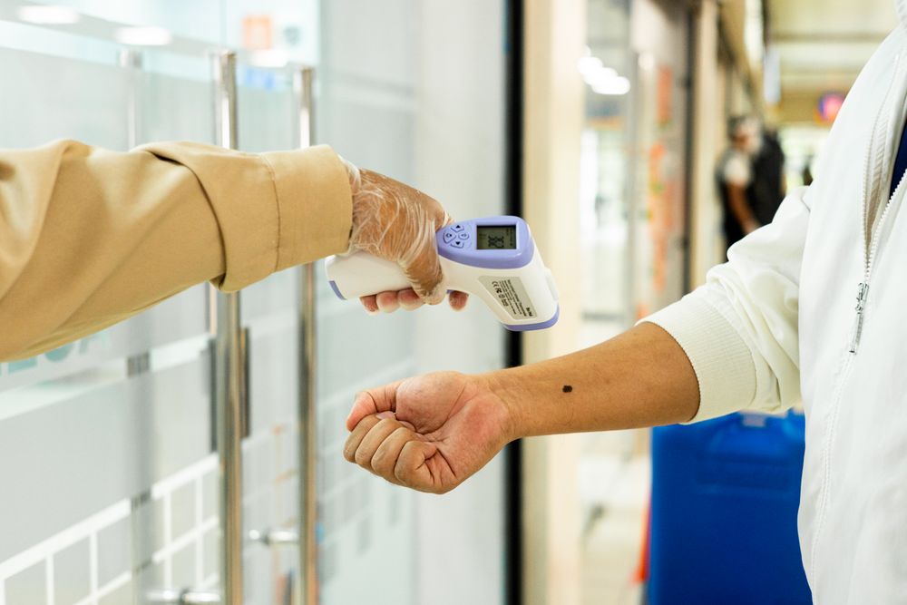 Person measuring another person's temperature