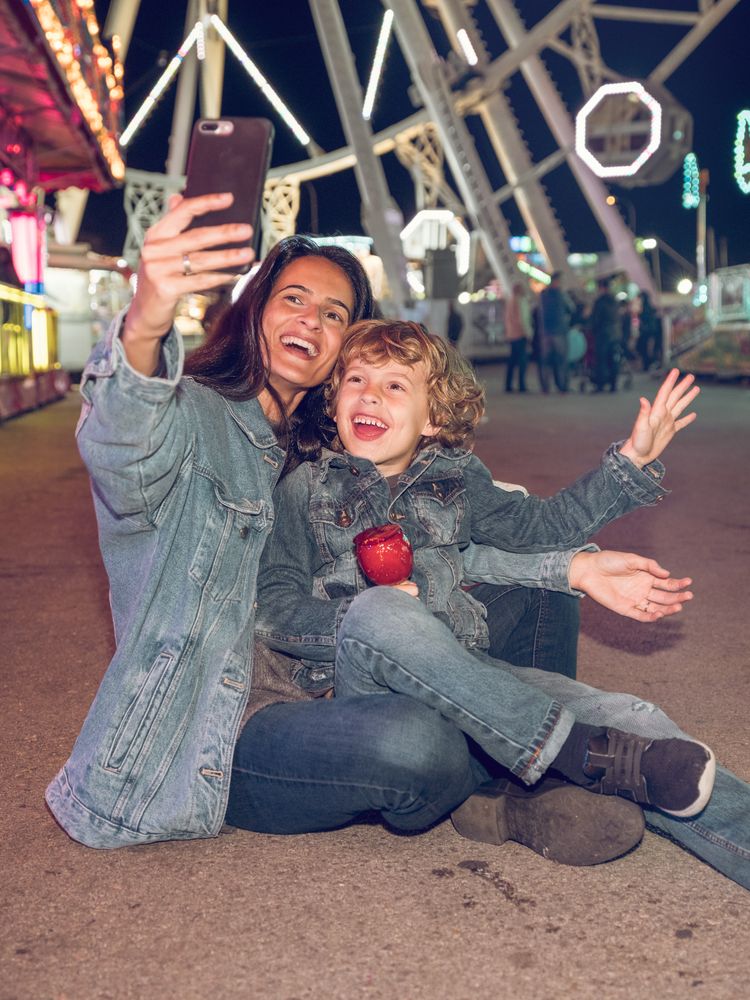 Happy mother and son taking selfie in amusement park