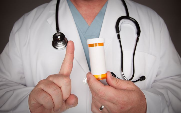 Male Doctor with Blank Medicine Bottle