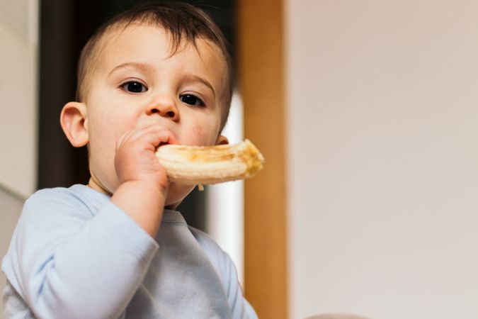 cute baby eating a banana at home