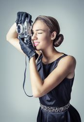 Model in vintage clothing and gloves taking photo