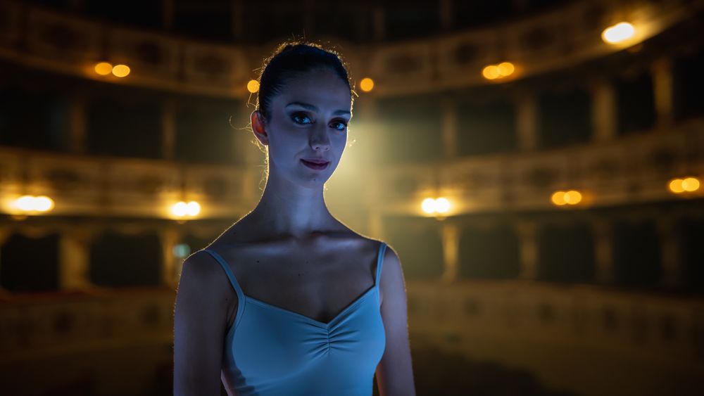 Cinematic Shot of Young Graceful Female Classical Ballet Dancer Looking at the Camera