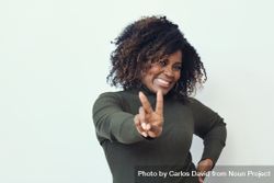 Smiling Black woman making the peace sign with her hands 5p9mN4